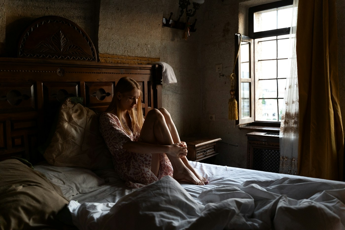 Woman sitting quietly by a window, reflecting on her thoughts