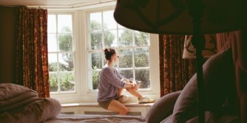 Woman sitting awake at night, caught in a cycle of worried thoughts