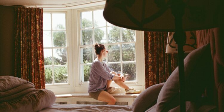 Woman sitting awake at night, caught in a cycle of worried thoughts